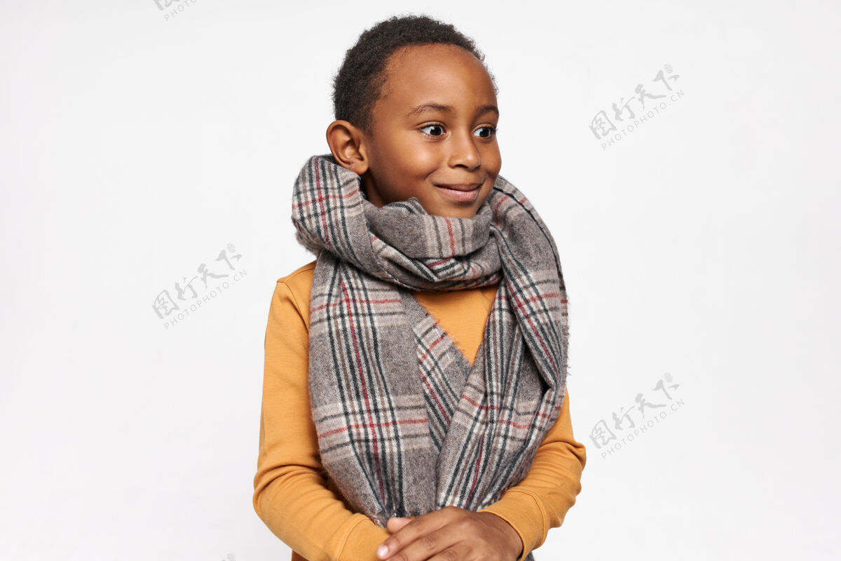 肖像童年的概念孤立的肖像情感惊讶可爱的黑色男孩戴着温暖的围巾微笑 弹出他的眼睛乐趣兴奋寒冷