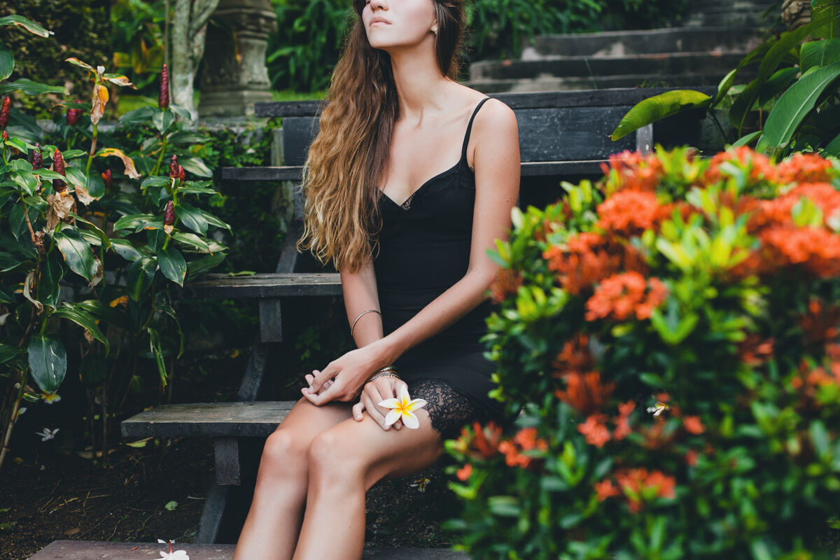 晒黑热带花园里年轻漂亮性感的女人 在泰国度暑假 苗条瘦削的棕褐色身材 带蕾丝的小黑裙 自然的造型 感性的 放松的 皮肤人优雅