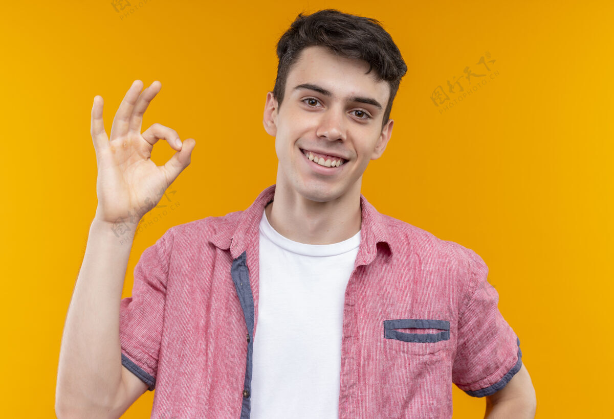 橙色微笑的白人年轻人穿着粉红色的衬衫 在孤立的橙色背景上显示出很好的姿态粉色衬衫手势