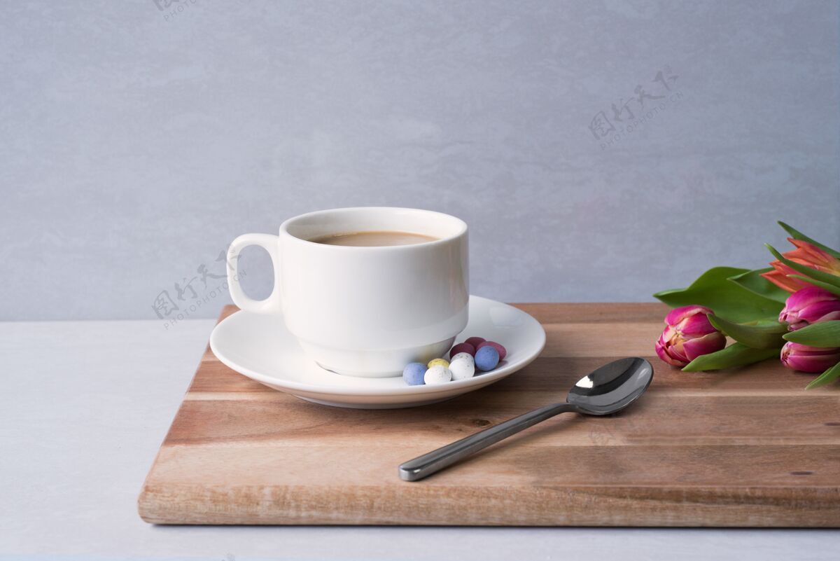 芳香特写镜头一杯热咖啡与牛奶在董事会附近的花束灯下咖啡特写郁金香