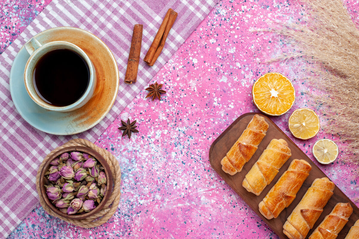 饼干在浅粉色的桌子上 俯瞰美味的小百吉饼 柠檬片和一杯茶小美味切片