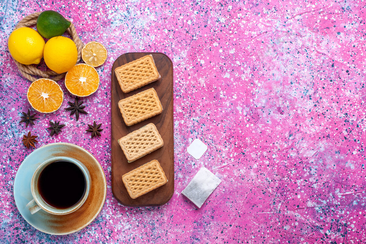 粉色在粉红色的桌子上可以看到新鲜的黄色柠檬 醇香的酸水果和华夫饼干三明治柑橘水果新鲜
