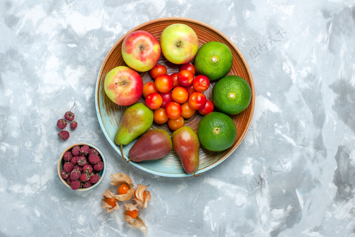 食品俯瞰白色书桌上的水果成分苹果梨橘子和李子李子苹果成分