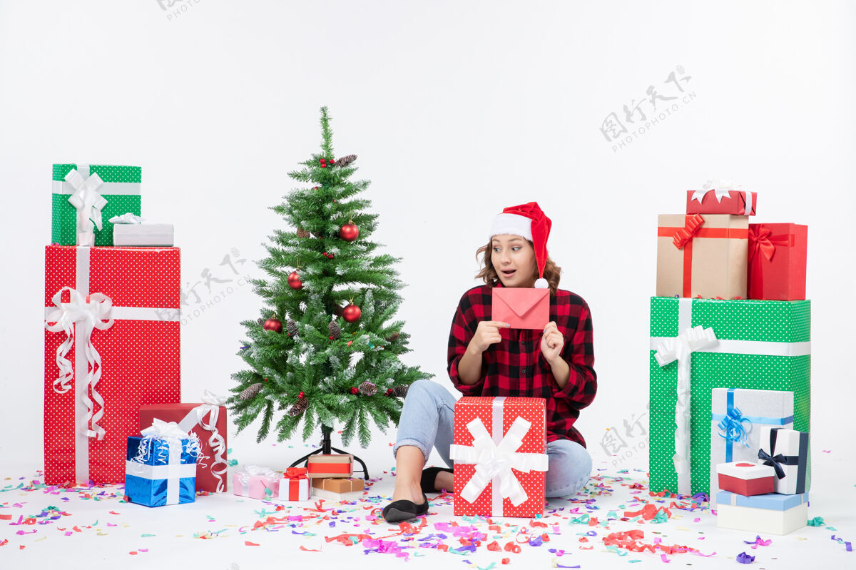 前面前视图年轻女子围坐在一个白色的墙上拿着信封的礼物人人礼物