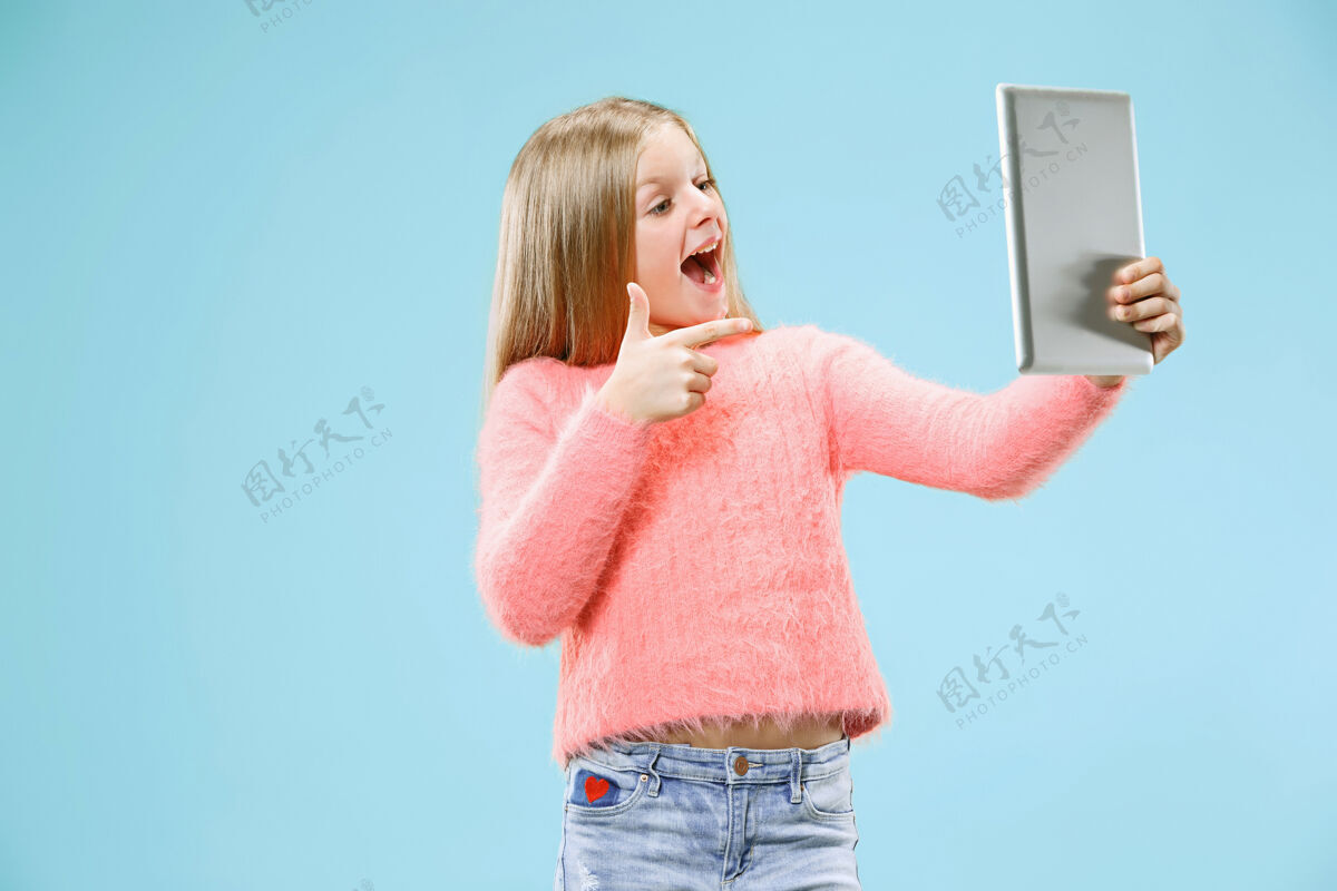 博客带笔记本电脑的少女热爱电脑概念迷人的女性半身正面肖像 时尚的蓝色工作室背景人类情感 面部表情概念工人笔记本面部