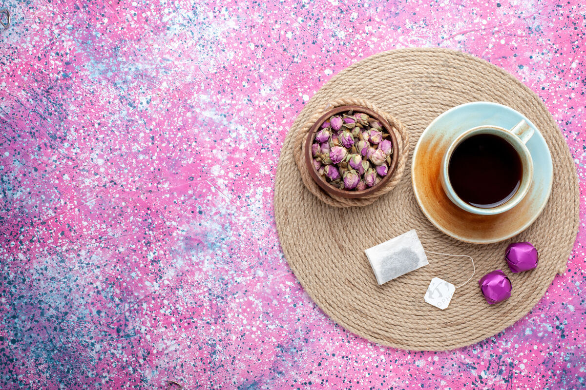 食物顶视图一杯茶 粉红色背景上有糖果茶邦邦巧克力