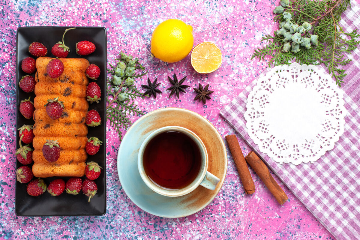 粉色在粉红色的桌子上 可以看到美味的蛋糕和新鲜的红色草莓柠檬茶饼干蛋糕饮料