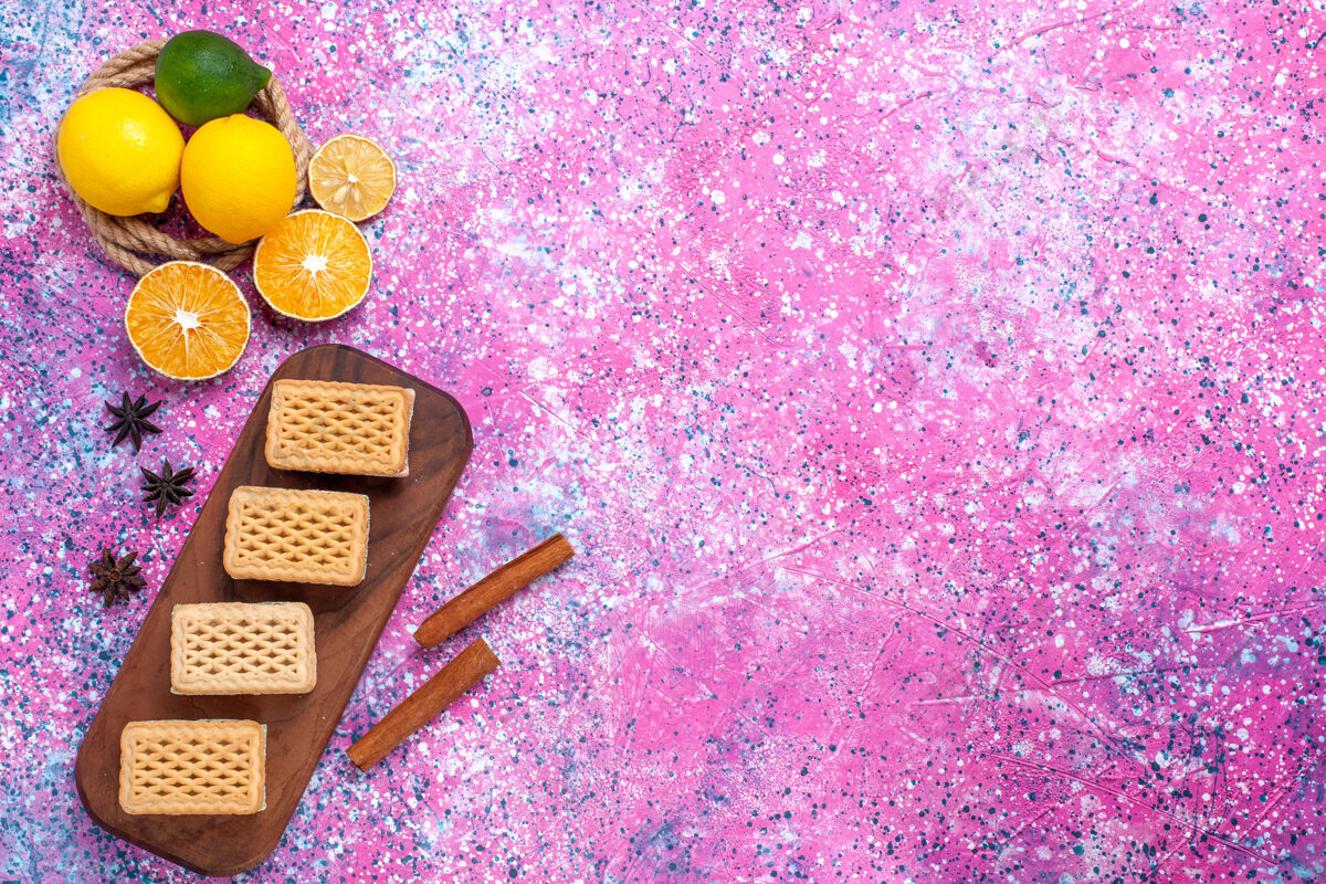 季节华夫饼三明治饼干的顶视图 带有水果奶油馅和浅粉色表面的茶装饰桌子甜点