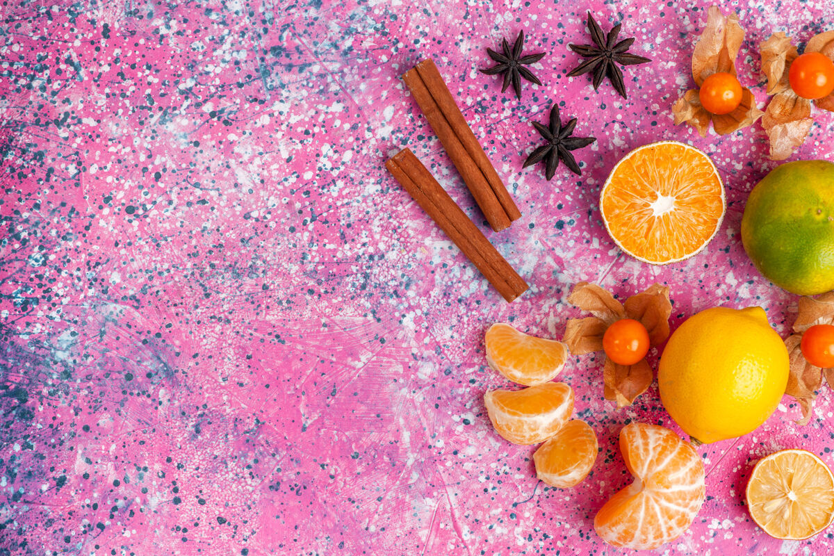 粉红色在浅粉色的背景上俯瞰新鲜的酸橘子和柠檬和肉桂柑橘花五颜六色
