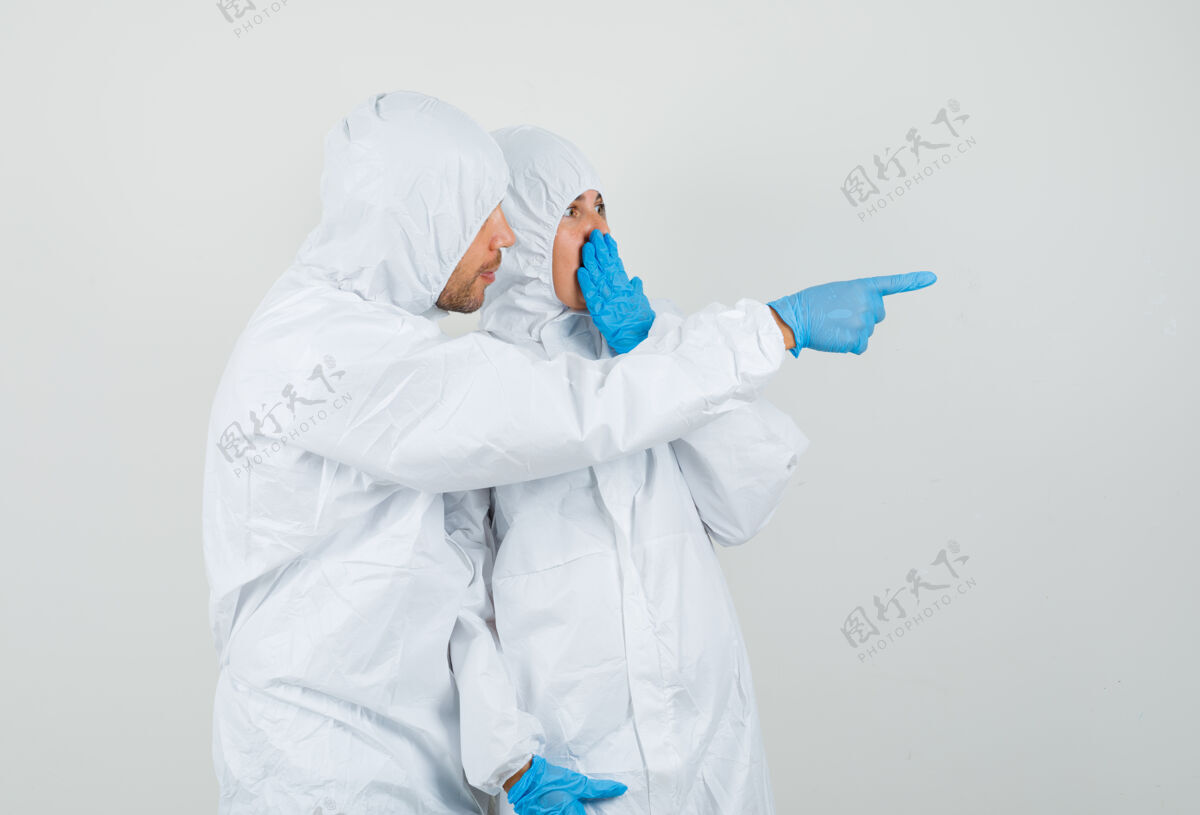 专业人士两个穿着防护服 戴着手套的医生在看一些令人惊讶的东西年轻人医院保健