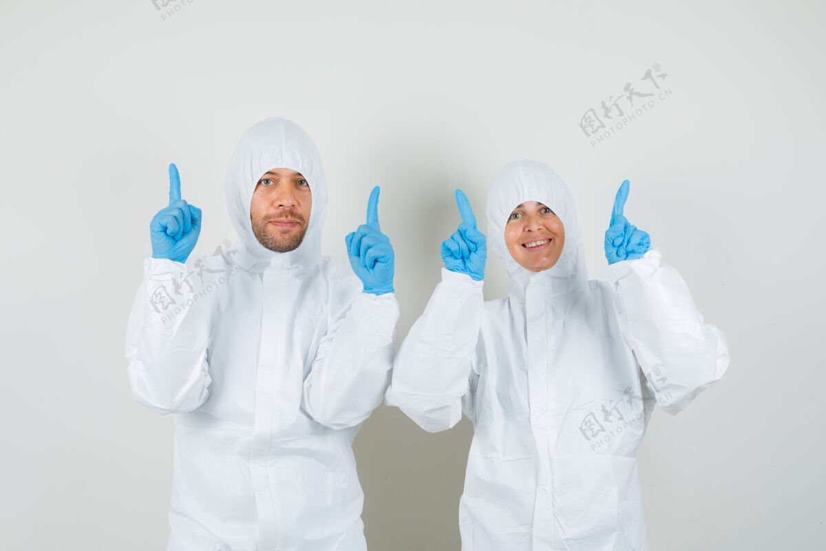 人两个医生穿着防护服 戴着手套 手指朝上 看上去很高兴医院专业人士外科医生