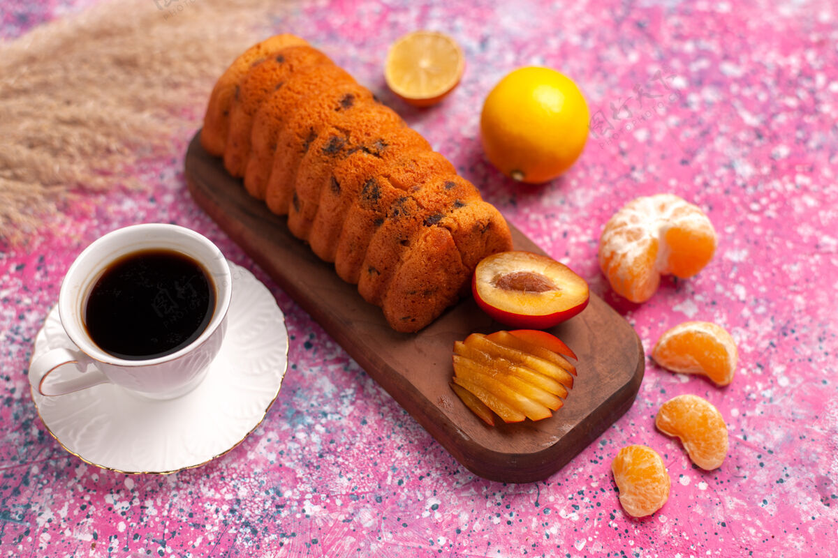 烘焙粉红色桌子上放着半顶美味的橘子蛋糕饼干美味面团