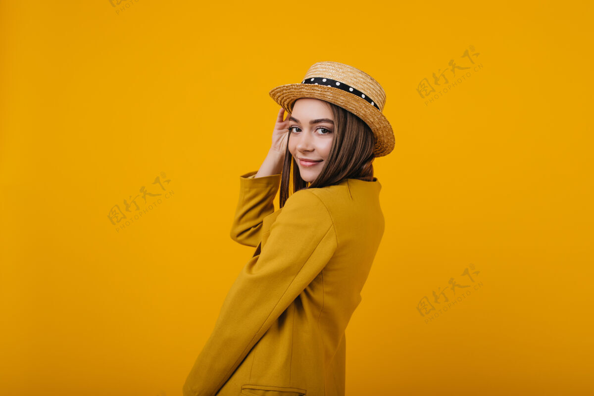 情感可爱的年轻女士穿着时髦的亮色夹克摆姿势戴草帽的女模特玩得很开心时尚时尚黄色