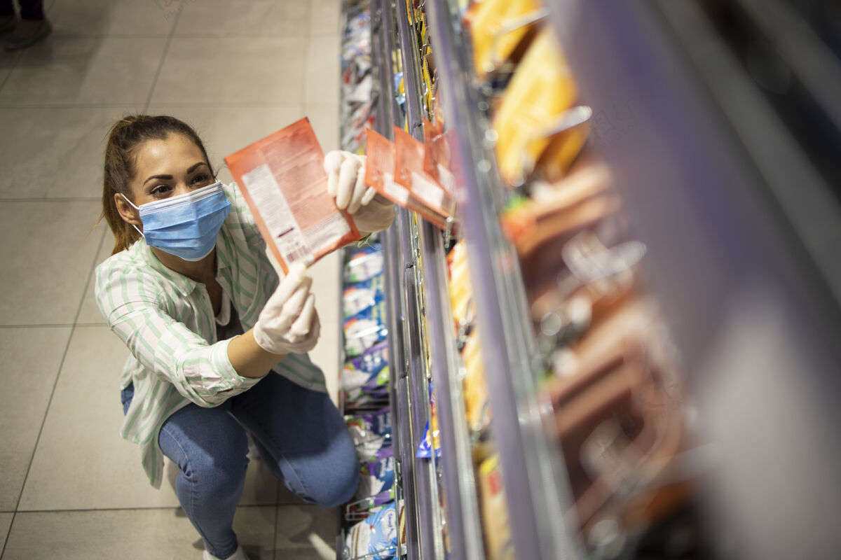 商店戴着口罩和手套在超市买食物的女性俯视图购物Covid19疾病