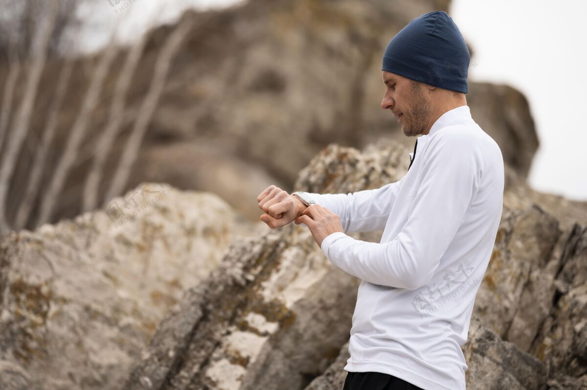运动大自然中的雄性在岩石附近看表自然健康慢跑