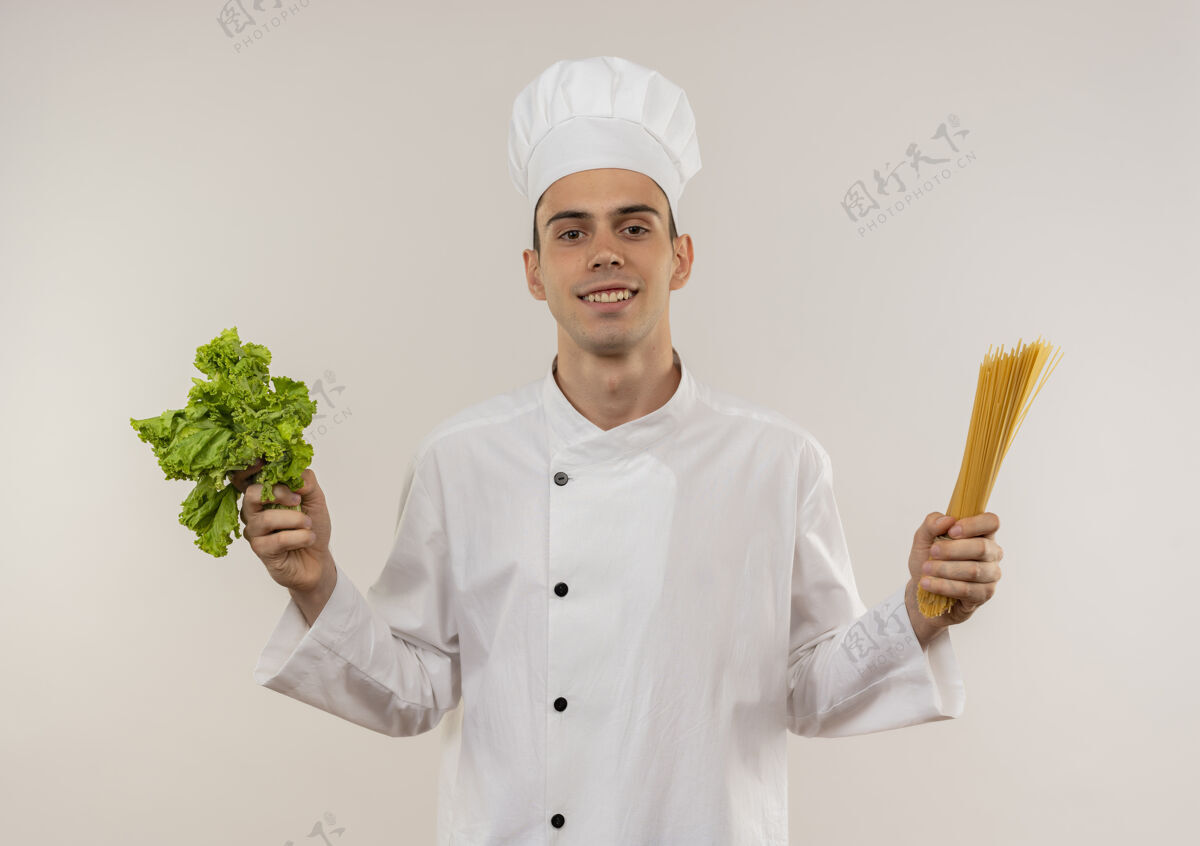 意大利面高兴的年轻男厨师穿着厨师制服拿着意大利面和沙拉戴着厨师拿着