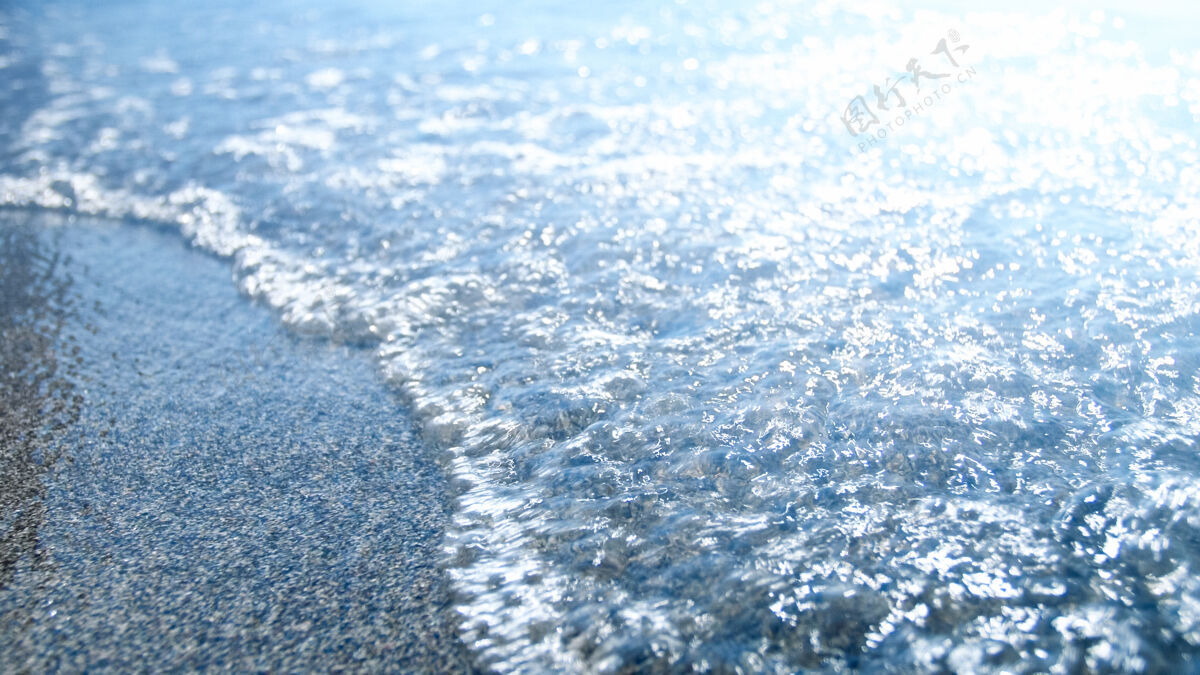 放松平静的蓝色海浪在沙滩上翻滚的特写镜头清澈水族旅游