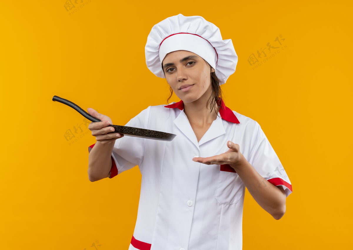 不放未出狱的年轻女厨师穿着厨师制服 手持并用手指着有复印空间的煎锅厨师制服厨师