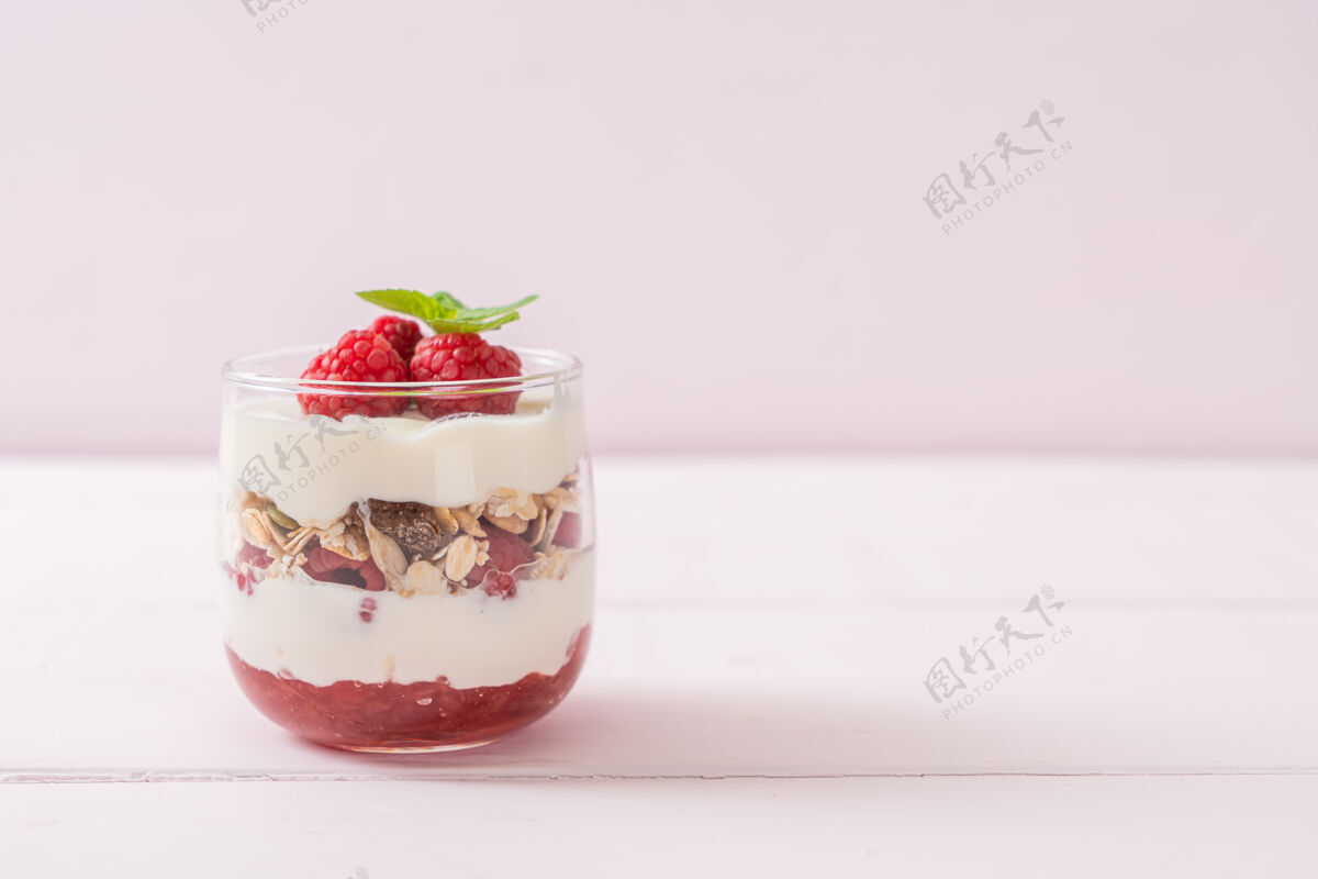 零食新鲜的覆盆子和酸奶与格兰诺拉麦片-健康的食物风格种子草莓早晨