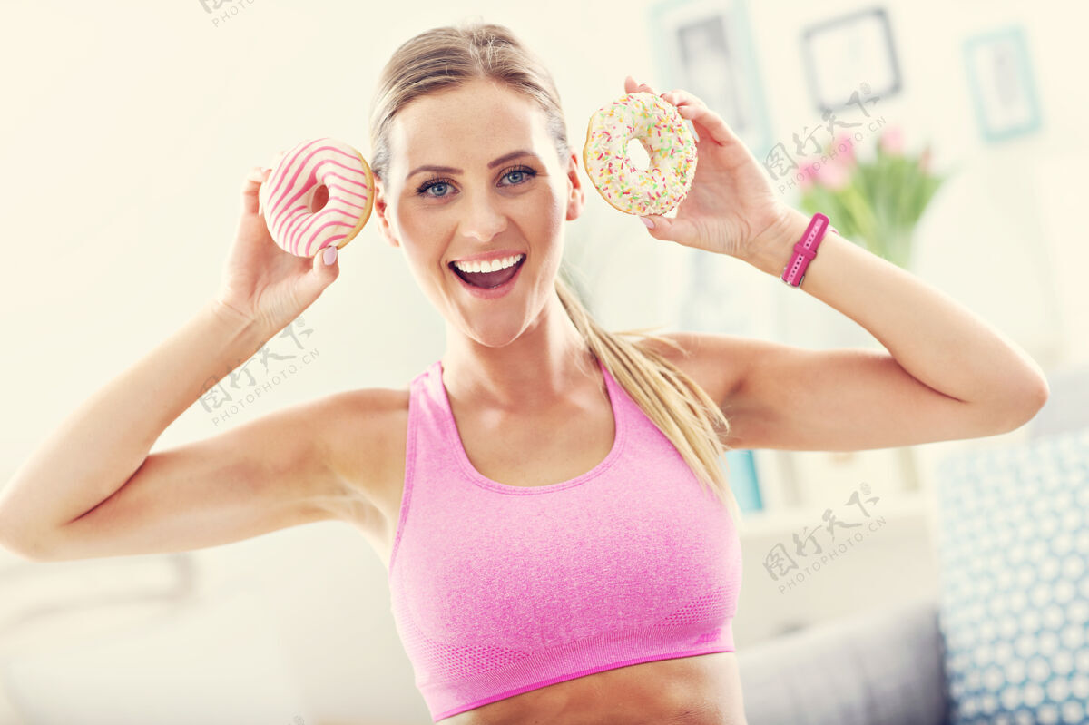 美丽运动后带甜甜圈的运动女人手健身效果