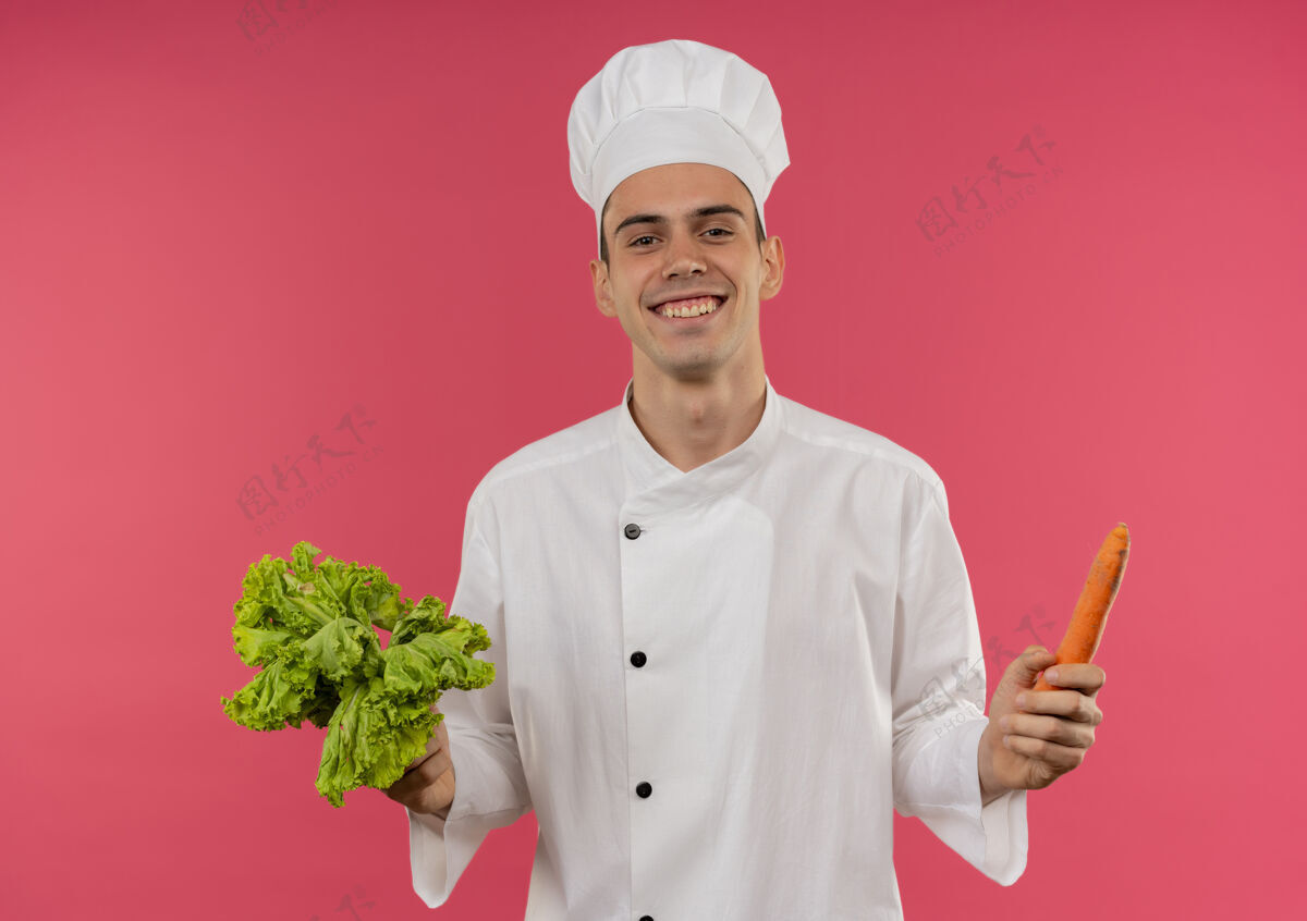 厨师面带微笑的年轻男厨师穿着厨师制服拿着沙拉和胡萝卜拿着沙拉制服