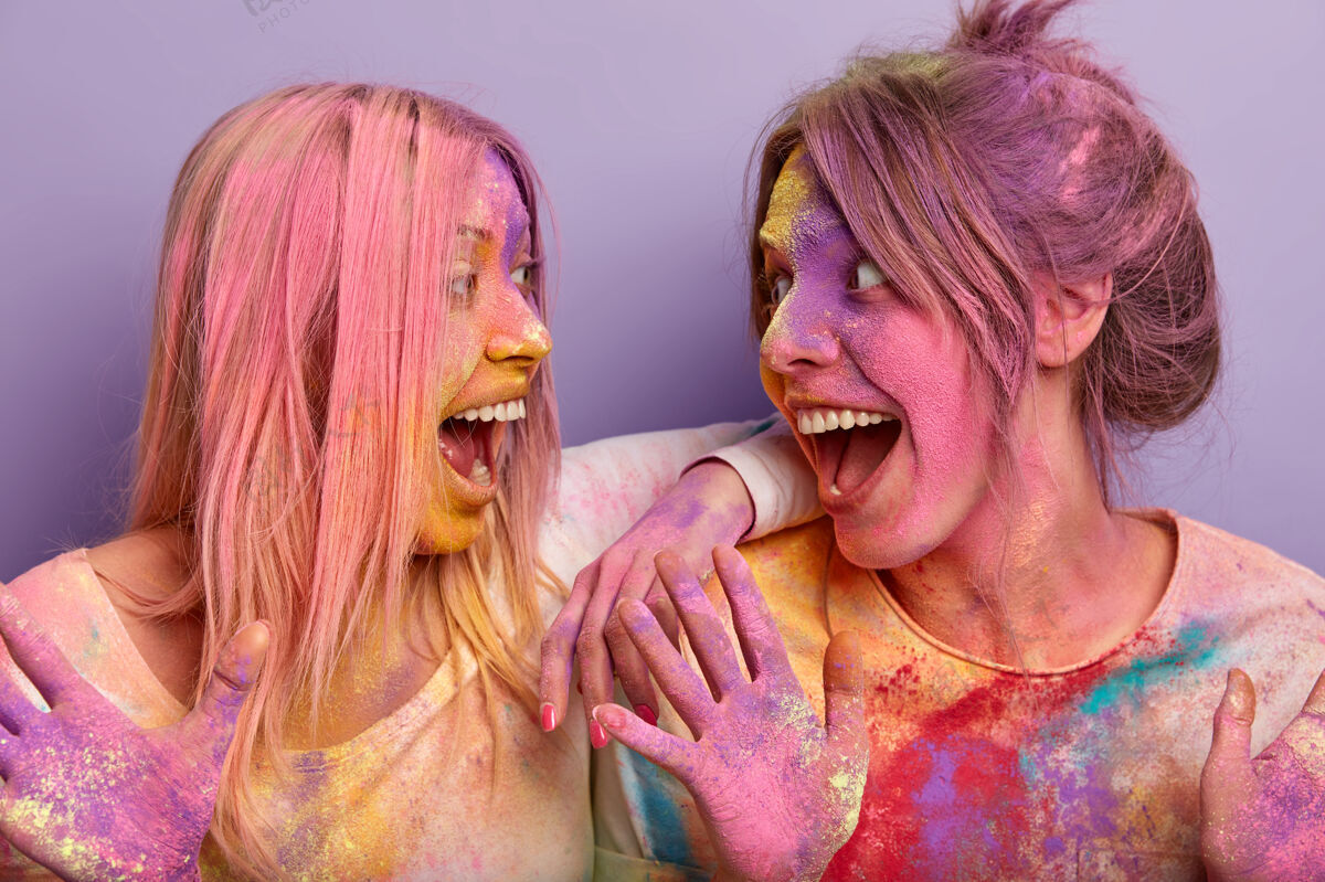 高兴横拍两位喜气洋洋的女人 头发 身体和衣服都是彩色的 庆祝胡里节 开心地看着对方笑乐观绘画