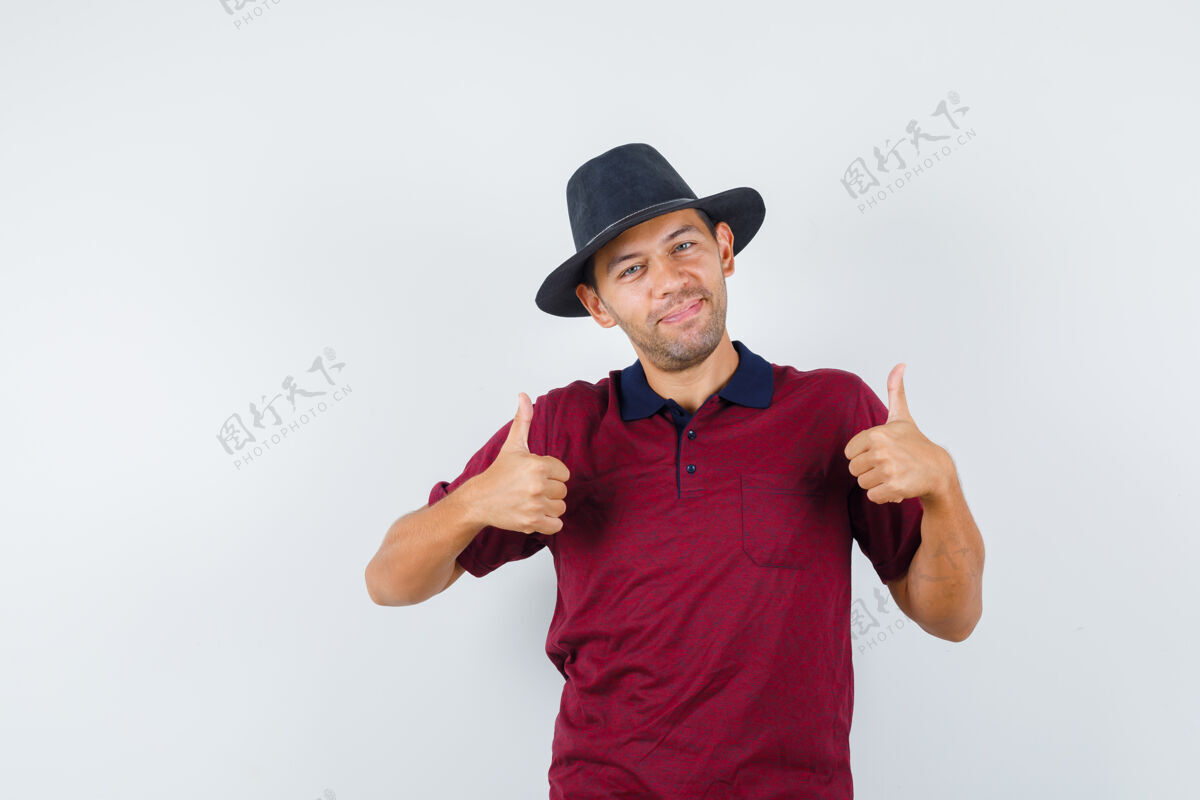 黑穿红衬衫 戴黑帽子的年轻男子抬起大拇指 看上去很高兴 正对着前方向上时尚自信