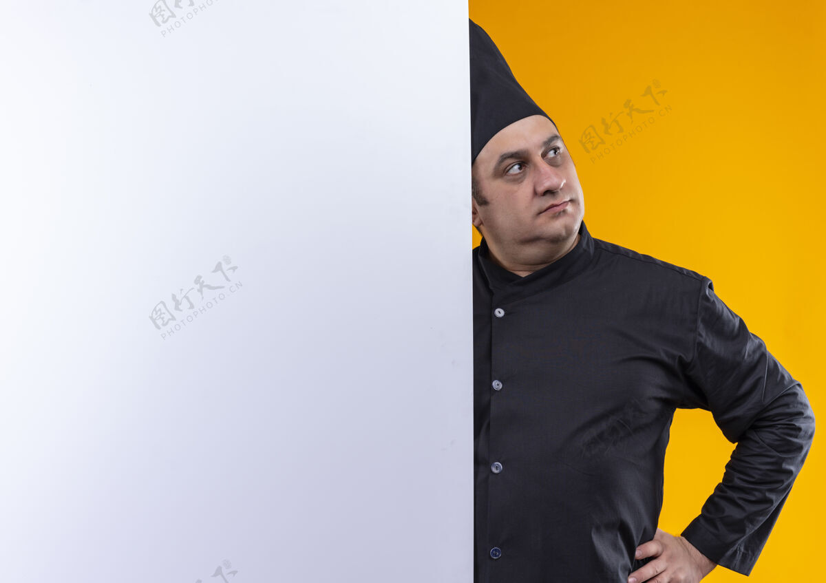 中年看着旁边穿着厨师制服的中年男厨师把他的手放在屁股上拿着白色的墙放在黄色的墙上留着复印空间厨师臀厨师