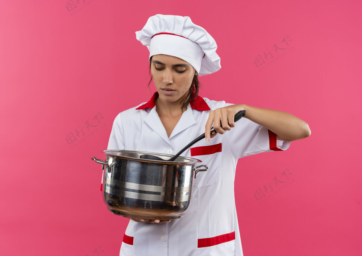 厨师想年轻的女厨师穿着厨师制服拿着一个看起来有复制空间的平底锅制服平底锅拿着