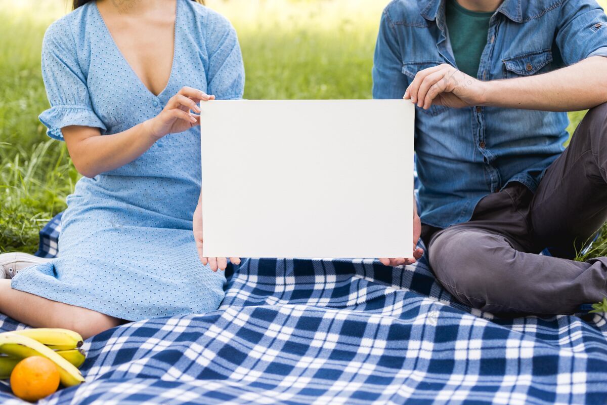 休闲时间一对夫妇拿着野餐模型的中镜头男性Up女性